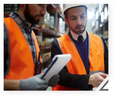 employees with hard hats looking at papers