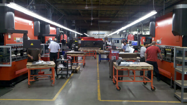 MASS Precision operators using Synergy SPC software on production floor.