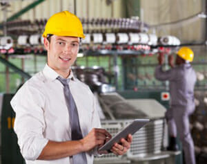 This is a picture of a man using Synergy SPC software on manufacturing floor.